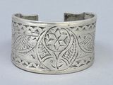 silver cuff bracelet with a design of fish and stars on it
