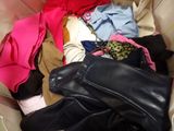 a pile of clothes in a bag with a pair of shoes
