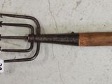 a pitchfork with a wooden handle and a tag on it