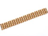 gros plan d'un bracelet en or sur une surface blanche