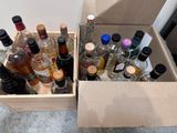 many bottles of alcohol in a box on the floor