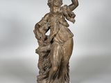 une statue en bronze représentant une femme avec un oiseau sur l'épaule