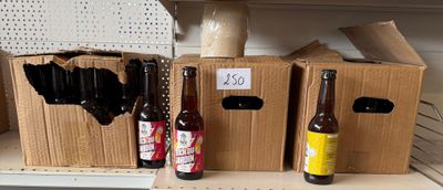 Plusieurs bouteilles de bière sont posées sur une étagère dans un magasin