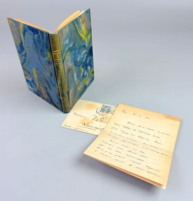 un livre ouvert posé sur une table à côté d'une feuille de papier