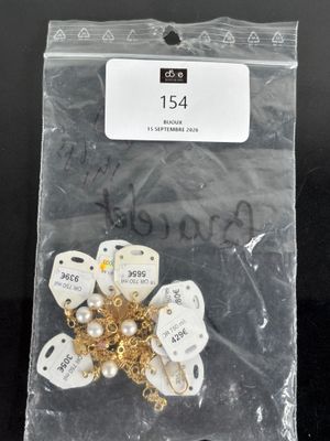 a bag of white and gold brooches on a black table