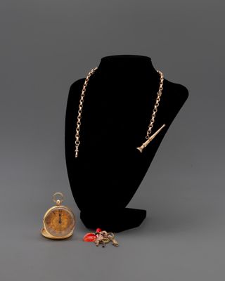 un collier et une montre posés sur un présentoir pour mannequin