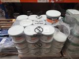 de nombreux pots de peinture posés sur une palette dans un magasin
