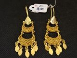une paire de boucles d'oreilles en or ornées de franges sur fond noir