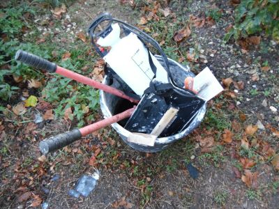un seau rempli de matériel électronique posé par terre