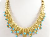 un collier en or orné de perles de turquoise sur un mannequin