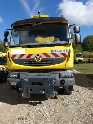 un camion jaune garé sur la terre battue