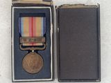 an image of a small medal in a box on a white surface