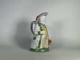 une figurine représentant une femme portant un chapeau et une robe