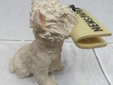 a white dog with a newspaper in its mouth