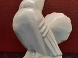 a white sculpture of a bird sitting on a table