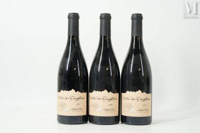 three bottles of wine are sitting on a white surface