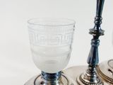 a silver plate with a glass on top of it