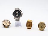 three watches and a watch stand on a white surface