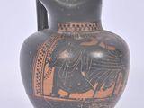 un vase noir et orange sur lequel figure l'image d'un homme à cheval