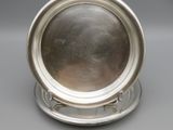 a silver plate with a circular design on a stand