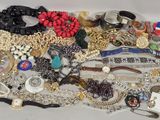 a pile of jewelry on a table with a white background