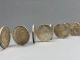 several coins are lined up in a row on a white surface