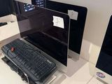 a laptop and a keyboard on a desk in front of a monitor