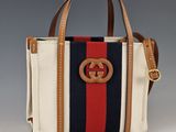 un gros plan sur un sac à main orné d'une rayure rouge, blanche et bleue