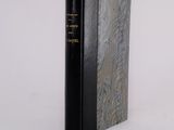 a black book sitting on top of a white table next to a white wall