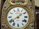 a gold clock with roman numerals on the face
