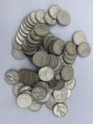 une pile de pièces d'argent posée sur une surface blanche