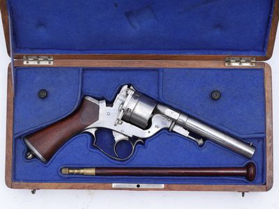 un revolver en argent dans un étui en bois muni d'une poignée en bois