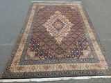 un grand tapis oriental orné d'un motif en médaillon sur fond gris