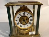 une horloge en or avec des chiffres romains, dans une vitrine