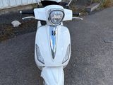 un scooter blanc garé devant un immeuble