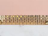 a close up of a gold bracelet on a marble surface
