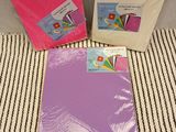three different colored cards and envelopes sitting on a striped surface