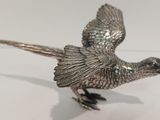 un oiseau argenté posé sur une surface blanche
