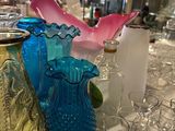 many different colored glass vases on the table