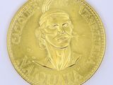 gold coin with a portrait of a woman wearing a headdress