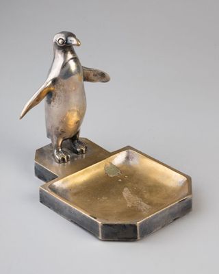 une photo d'une figurine de pingouin posée sur un plateau en métal
