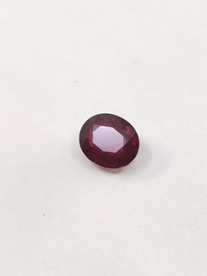 gros plan d'une pierre de rubis rouge sur une surface blanche