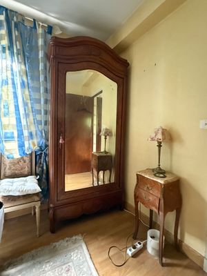 a mirror in the corner of a room next to a dresser