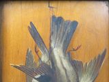 une peinture représentant deux oiseaux sur une surface en bois