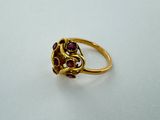 a close up of a gold ring with red stones on it