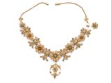 un collier en or orné de pierres vertes et blanches, montées sur une chaîne