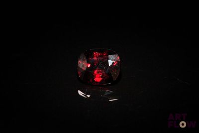 a close up of a red diamond on a black surface