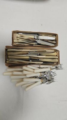 plusieurs fourchettes et couteaux dans une boîte en bois posée sur une table