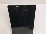 the back of a black laptop computer sitting on top of a white table