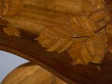 a close up of a wooden table with a leaf design on it